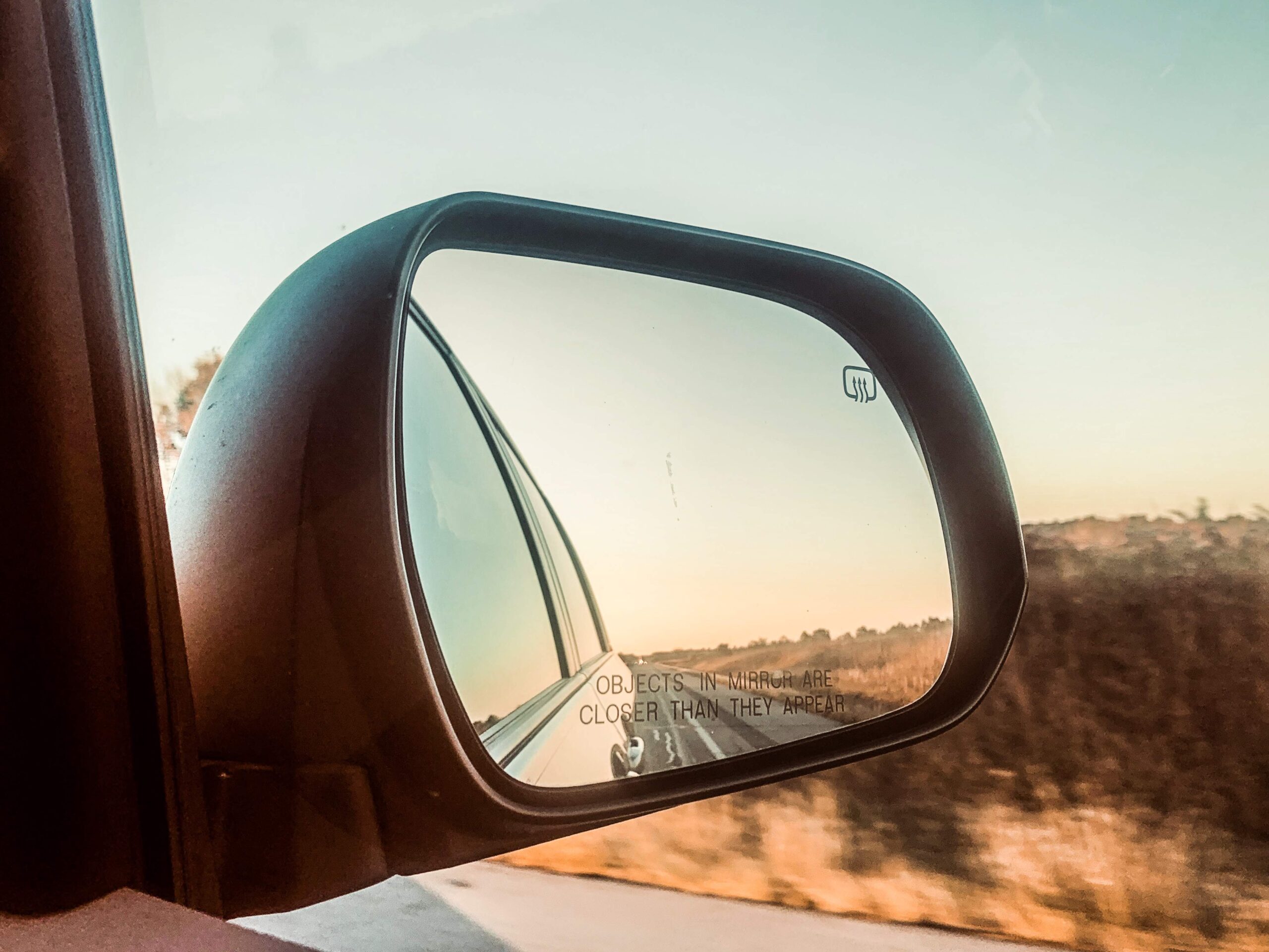 side mirror of car on road trip