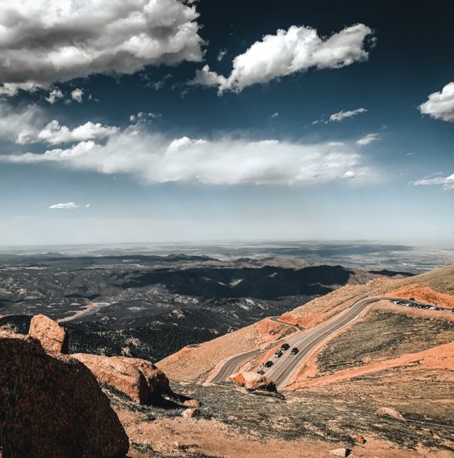 mountains and sky and clouds and road and bushes