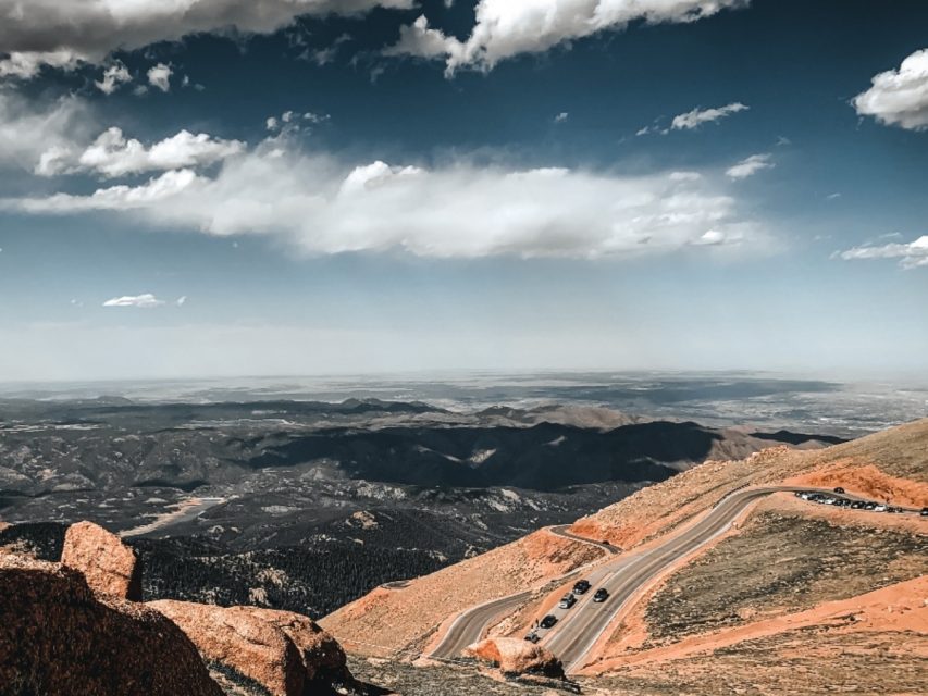 mountains and sky and clouds and road and bushes